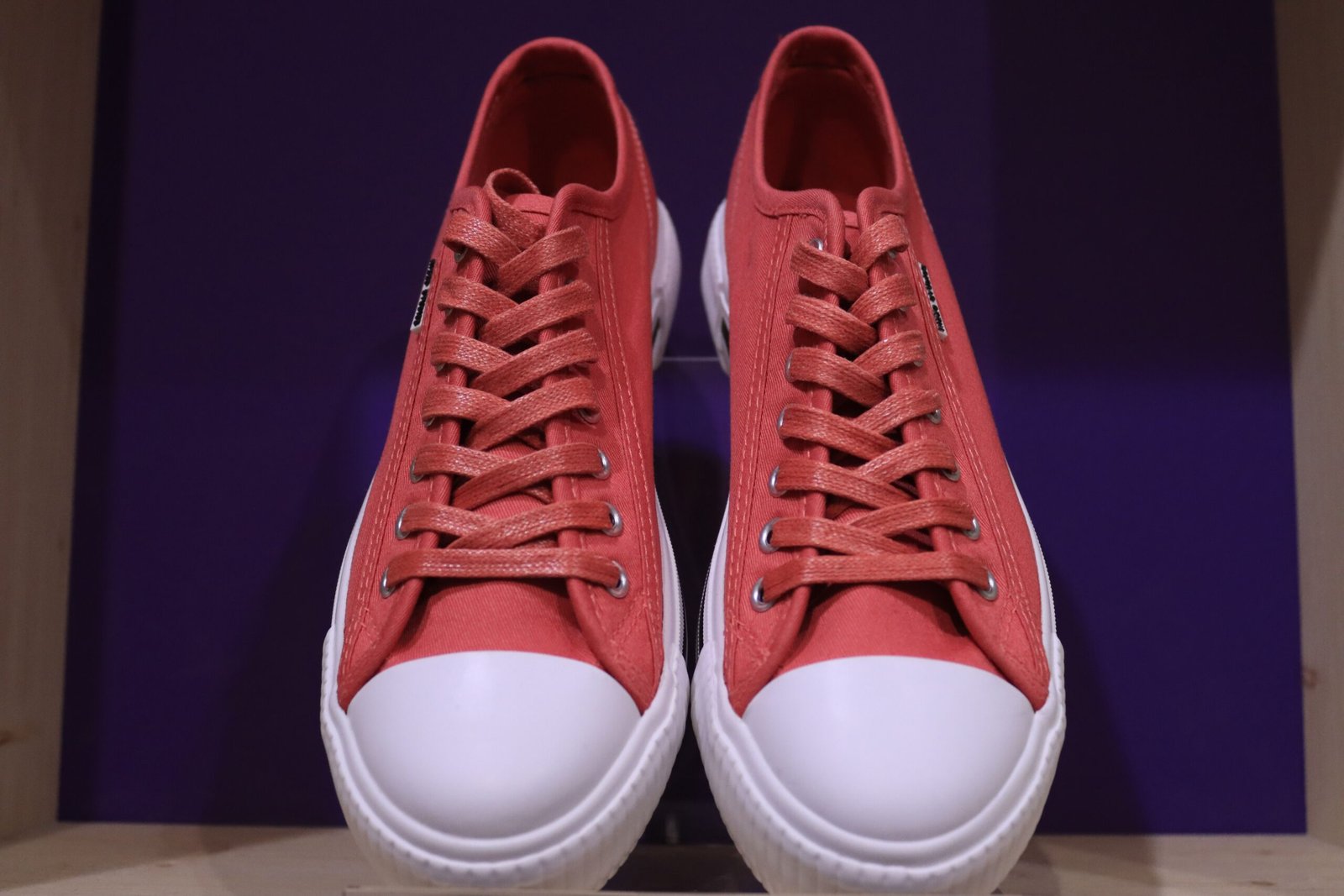 pexels photo 12526086 12526086 Stylish red sneakers with white soles and shoelaces on a display shelf in Jönköping, Sweden.